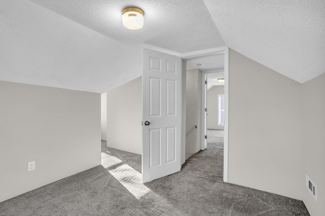 bonus room featuring carpet flooring, a textured ceiling, and vaulted ceiling