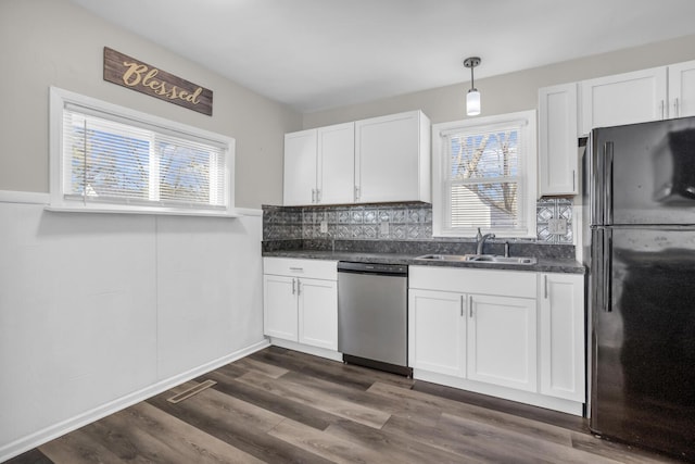 kitchen with dishwasher, black refrigerator, white cabinetry, and hanging light fixtures