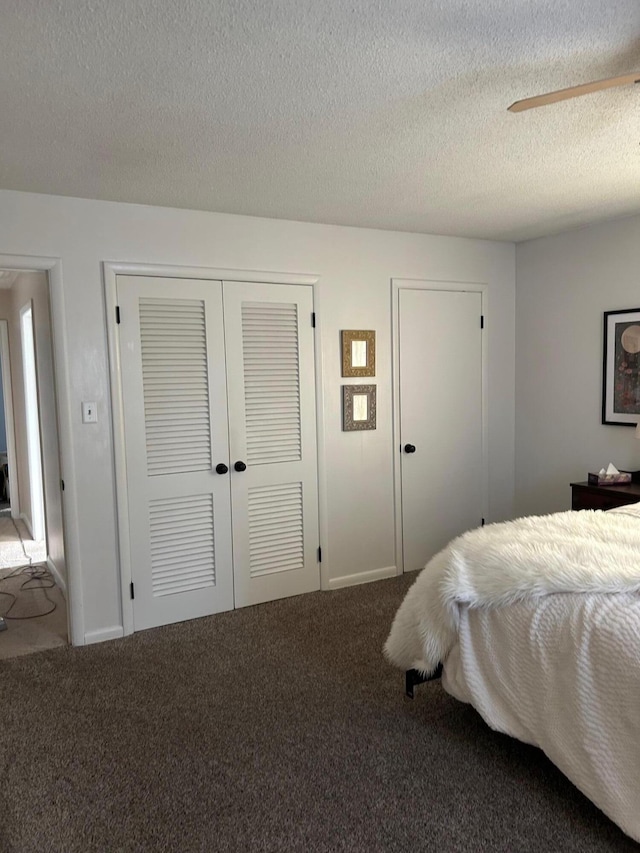 carpeted bedroom featuring a textured ceiling and ceiling fan