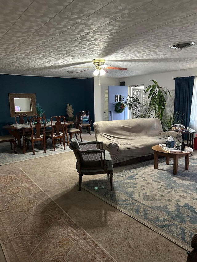 living room featuring ceiling fan and a textured ceiling