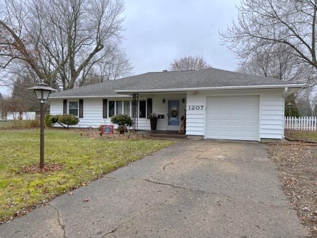 single story home featuring a garage and a front yard