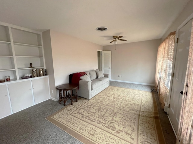 living room with ceiling fan and built in shelves