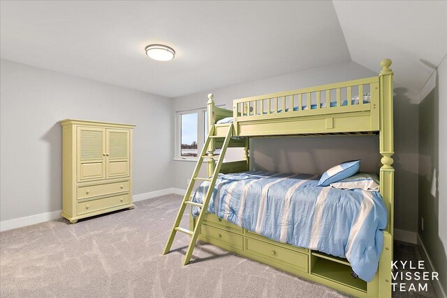 carpeted bedroom with lofted ceiling