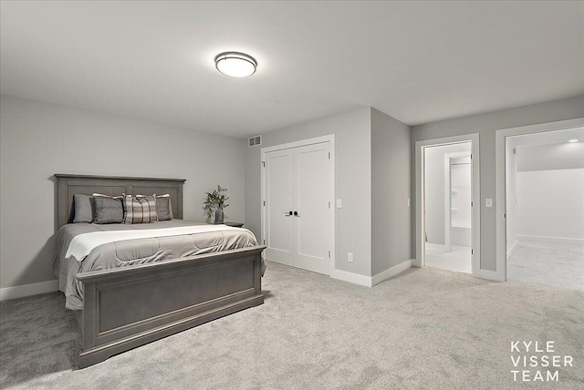 bedroom with light carpet and ensuite bath