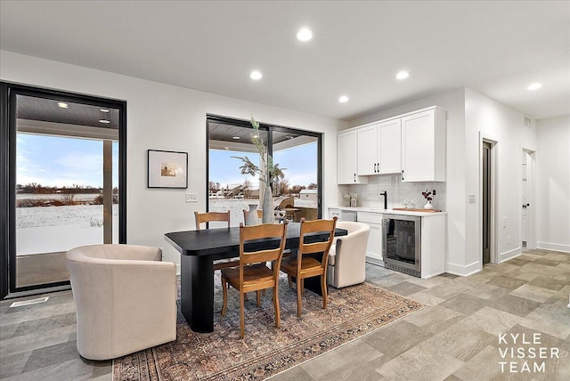 dining area with plenty of natural light, beverage cooler, and sink