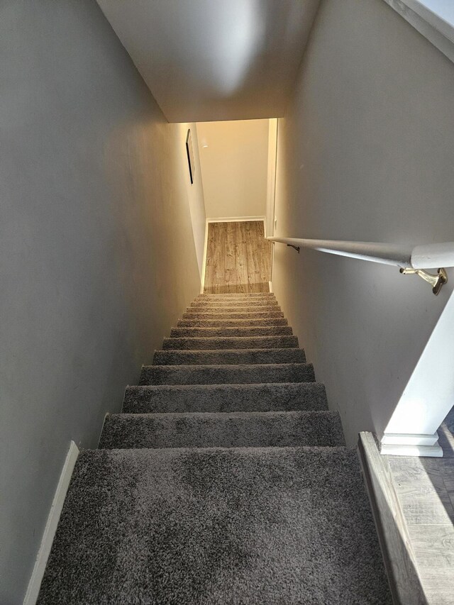 stairway featuring wood finished floors and baseboards