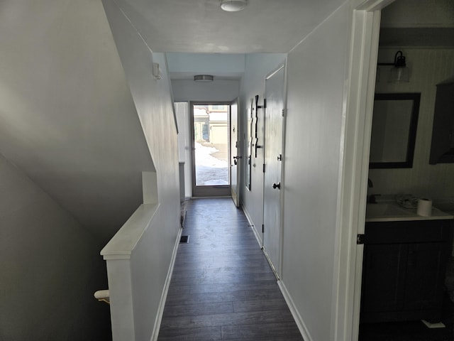 hallway featuring baseboards, visible vents, and dark wood finished floors