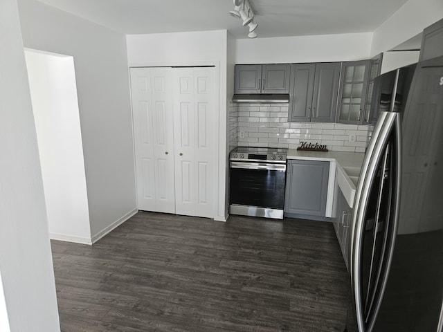 kitchen featuring dark wood-style flooring, light countertops, appliances with stainless steel finishes, gray cabinets, and glass insert cabinets