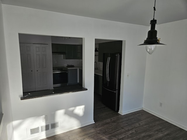 interior space with tasteful backsplash, visible vents, range with electric cooktop, dark wood finished floors, and freestanding refrigerator