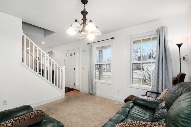 living room featuring light carpet and an inviting chandelier