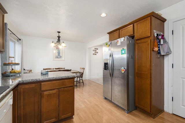 kitchen featuring stainless steel fridge, an inviting chandelier, dishwasher, light hardwood / wood-style floors, and hanging light fixtures