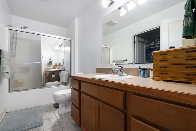 full bathroom featuring shower / bath combination with glass door, tile patterned floors, vanity, and toilet