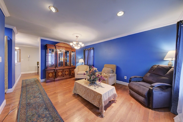 living room with light hardwood / wood-style floors, an inviting chandelier, and ornamental molding