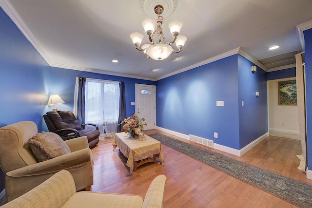 living room featuring a notable chandelier, wood-type flooring, and crown molding