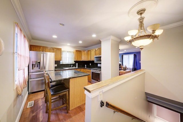 kitchen featuring a center island, dark wood-type flooring, stainless steel appliances, backsplash, and a breakfast bar