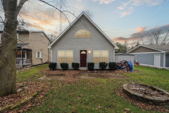 rear view of house featuring an outdoor fire pit, an outbuilding, and a yard