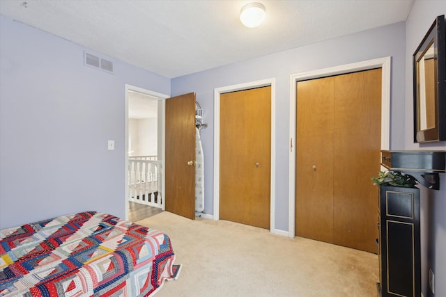 carpeted bedroom featuring multiple closets