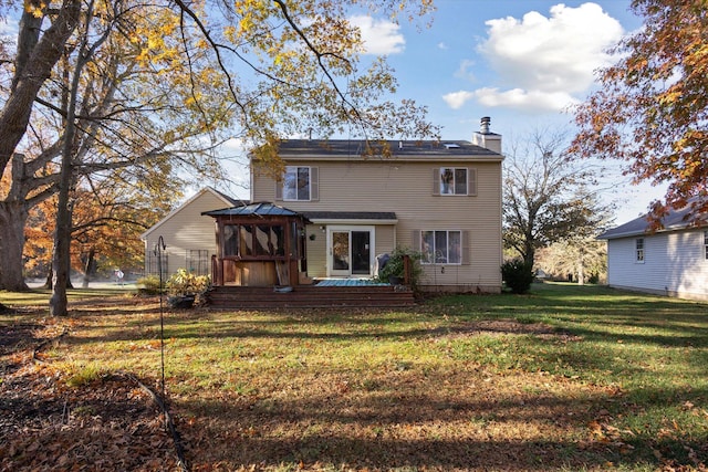 rear view of property featuring a lawn and a wooden deck