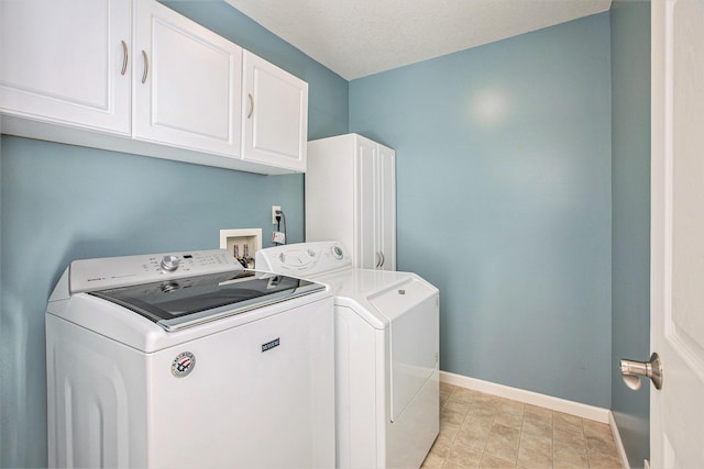 laundry room with cabinets, a textured ceiling, and independent washer and dryer