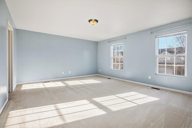 carpeted spare room with a healthy amount of sunlight