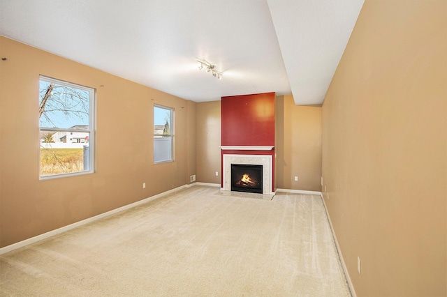 unfurnished living room with light colored carpet and track lighting