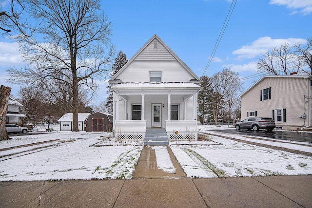 bungalow-style house featuring covered porch and an outbuilding