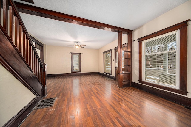 foyer featuring ceiling fan, a textured ceiling, and dark wood-type flooring