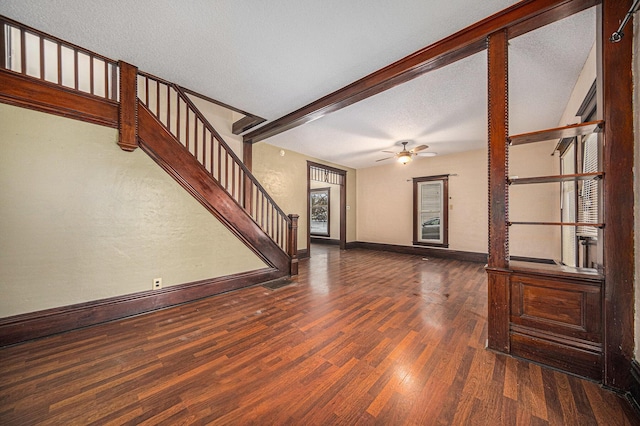 living room featuring ceiling fan, a textured ceiling, and dark wood-type flooring