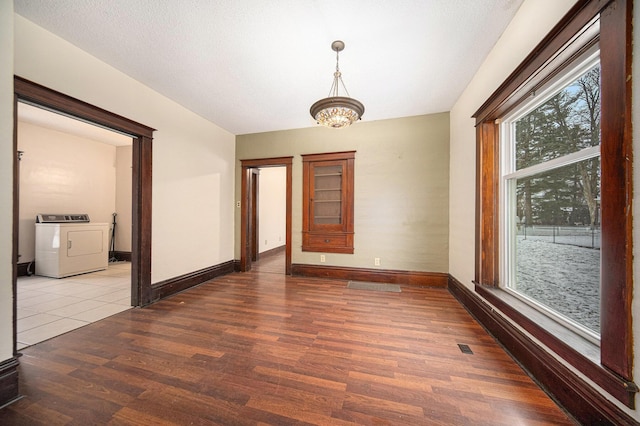 unfurnished room with a chandelier, wood-type flooring, and independent washer and dryer