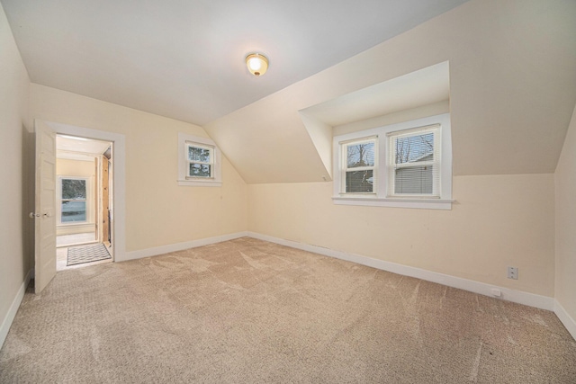 bonus room with light carpet and lofted ceiling