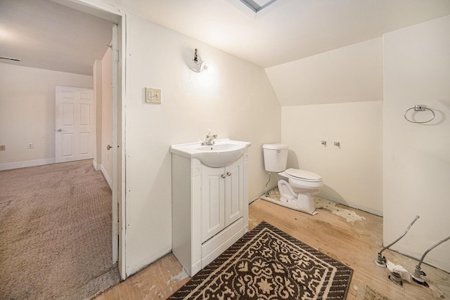 bathroom with vanity, toilet, and vaulted ceiling