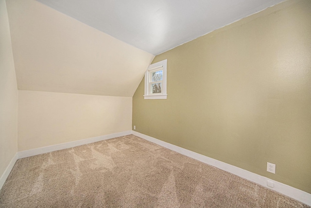 additional living space featuring carpet flooring and vaulted ceiling