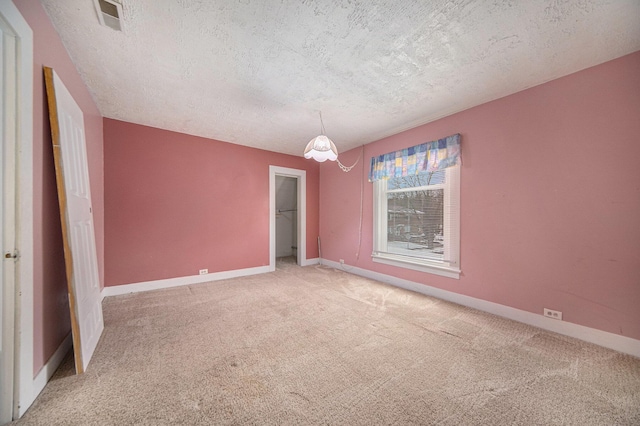 carpeted empty room with a textured ceiling