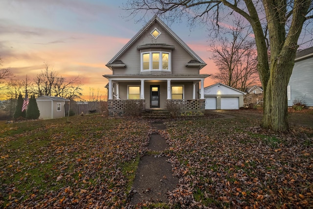 view of front of home with a porch, a garage, and a shed