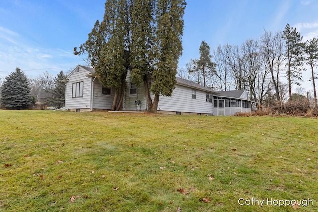 rear view of property with a lawn and a sunroom