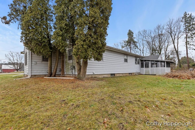 back of property featuring a sunroom and a yard