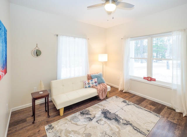 living area featuring ceiling fan and dark hardwood / wood-style floors