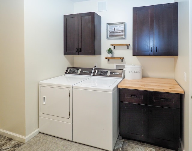 clothes washing area with cabinets and independent washer and dryer