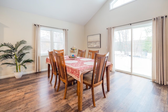 dining area with dark wood-type flooring, a wealth of natural light, and vaulted ceiling