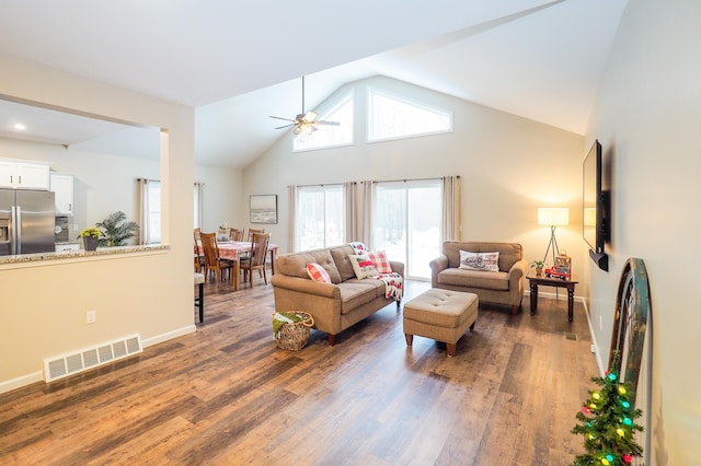 living room with ceiling fan, dark hardwood / wood-style flooring, and vaulted ceiling