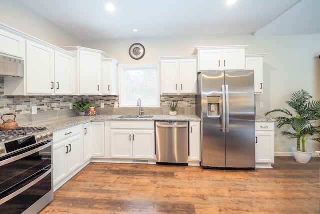 kitchen featuring light stone counters, white cabinetry, sink, and appliances with stainless steel finishes