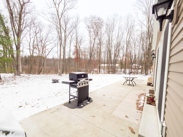 snow covered patio featuring a grill