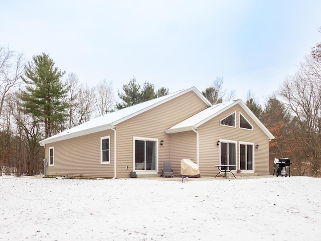 view of snow covered back of property