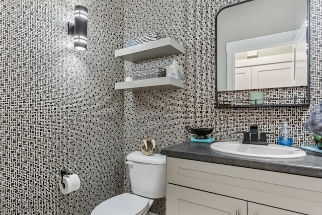 bathroom featuring vanity, tasteful backsplash, toilet, and tile walls