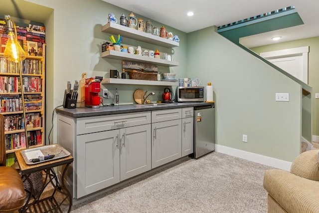 bar featuring gray cabinetry, light carpet, sink, and refrigerator