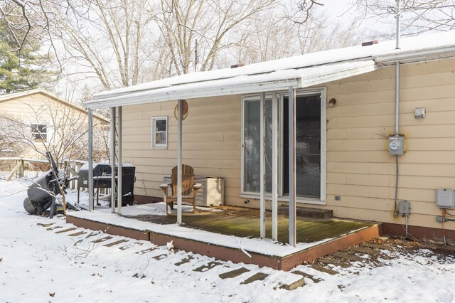 view of snow covered back of property