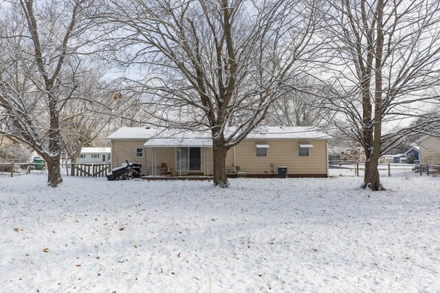 snow covered back of property with central AC