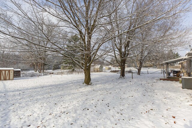 snowy yard featuring central air condition unit