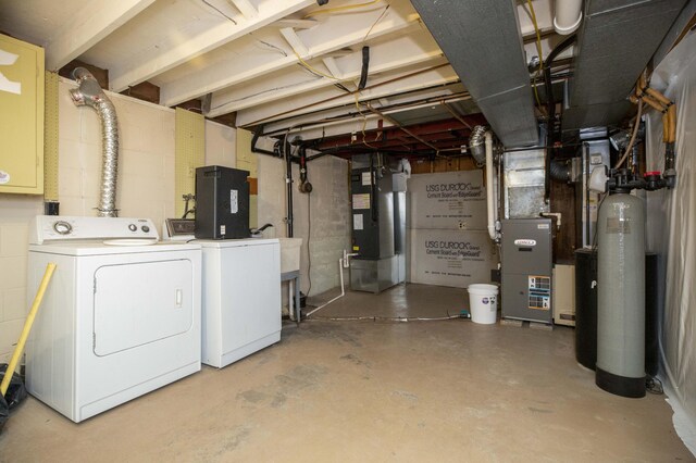 basement with washing machine and clothes dryer and heating unit