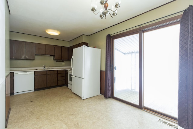 kitchen with dark brown cabinetry, white appliances, sink, and a chandelier